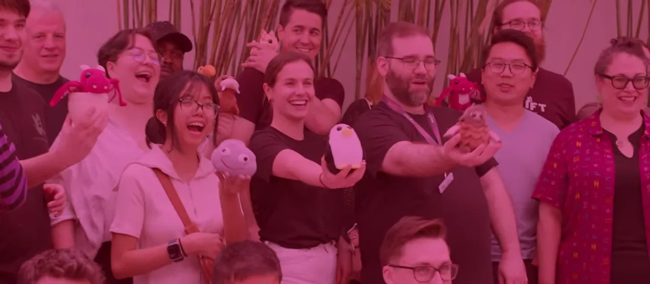 A group of Uplift Games team members smiling while holding plushies.