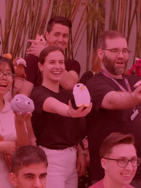A group of Uplift Games team members smiling while holding plushies.